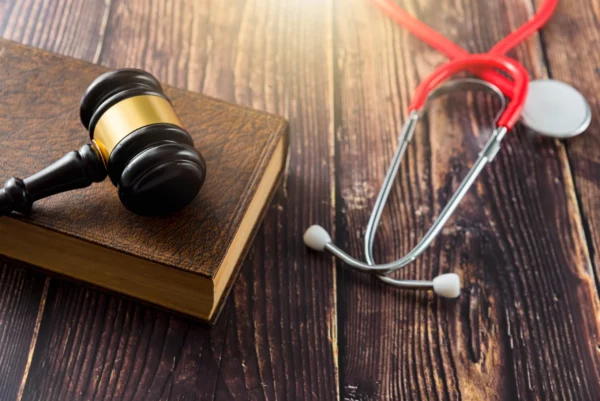 Judge’s gavel resting on a law book beside a red stethoscope, symbolizing legal and medical considerations in will challenges