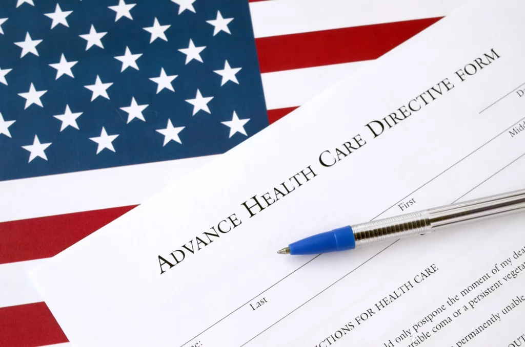 Advance health care directive form with pen on top of an American flag, representing legal planning for medical decisions in Houston.